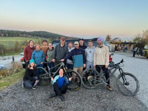 Eine gemischte Personengruppe posiert auf dem Parkplatz der Wexl Trails gemeinsam für ein Foto